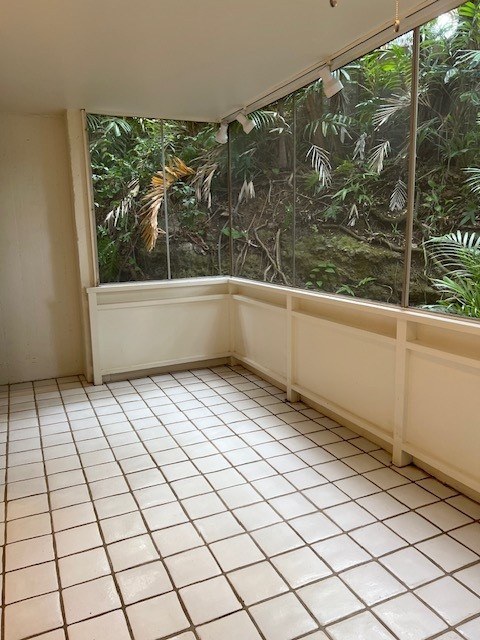 A room with a tiled floor and a window overlooking a forest.